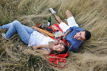 Image showing happy couple enjoying countryside picnic in long grass