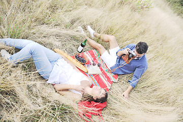 Image showing happy couple enjoying countryside picnic in long grass