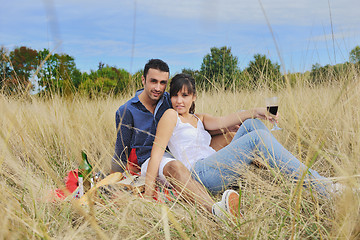 Image showing happy couple enjoying countryside picnic in long grass