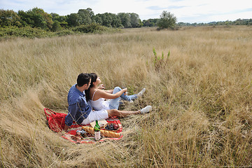 Image showing happy couple enjoying countryside picnic in long grass