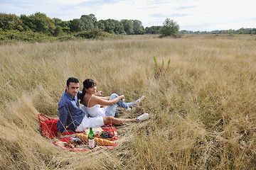 Image showing happy couple enjoying countryside picnic in long grass