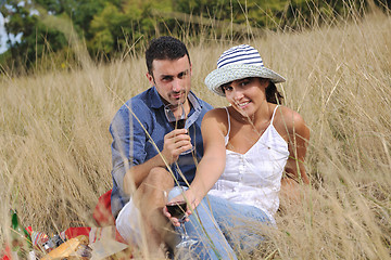 Image showing happy couple enjoying countryside picnic in long grass