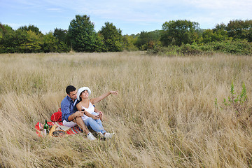 Image showing happy couple enjoying countryside picnic in long grass