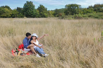 Image showing happy couple enjoying countryside picnic in long grass