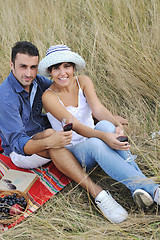 Image showing happy couple enjoying countryside picnic in long grass