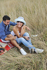 Image showing happy couple enjoying countryside picnic in long grass