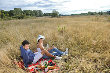 Image showing happy couple enjoying countryside picnic in long grass