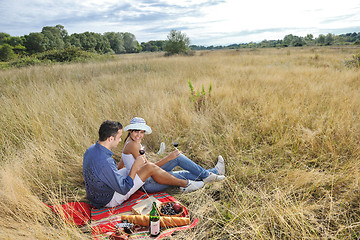 Image showing happy couple enjoying countryside picnic in long grass