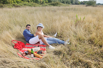 Image showing happy couple enjoying countryside picnic in long grass