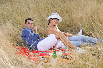 Image showing happy couple enjoying countryside picnic in long grass