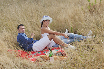 Image showing happy couple enjoying countryside picnic in long grass