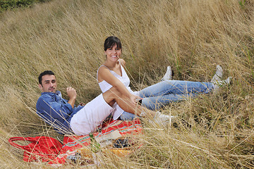 Image showing happy couple enjoying countryside picnic in long grass