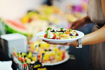 Image showing womanl chooses tasty meal in buffet at hotel