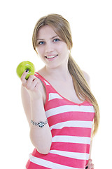 Image showing happy  young  woman eat green apple isolated  on white