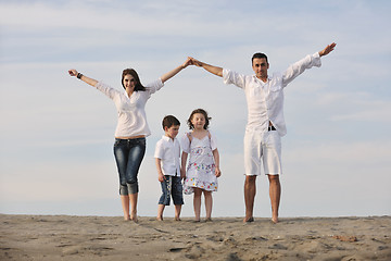 Image showing family on beach showing home sign