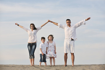 Image showing family on beach showing home sign