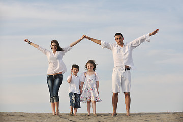 Image showing family on beach showing home sign