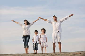 Image showing family on beach showing home sign