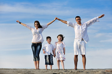 Image showing family on beach showing home sign