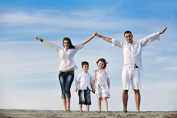 Image showing family on beach showing home sign