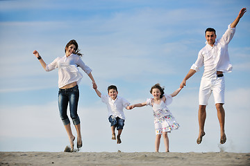 Image showing family on beach showing home sign