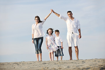 Image showing family on beach showing home sign