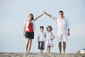 Image showing family on beach showing home sign