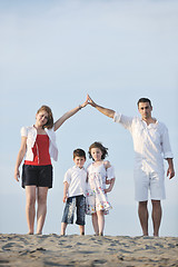 Image showing family on beach showing home sign