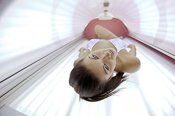 Image showing Beautiful young woman tanning in solarium