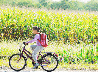 Image showing schoolgirl traveling to school on bicycle