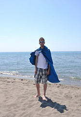 Image showing funny superhero standing on beach