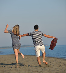 Image showing couple on beach with travel bag