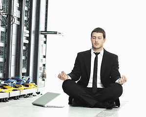 Image showing businessman with laptop in network server room