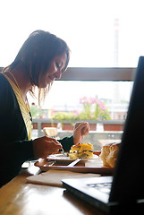 Image showing woman eating at an restaurant