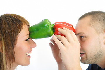 Image showing happy couple holding peppers with head