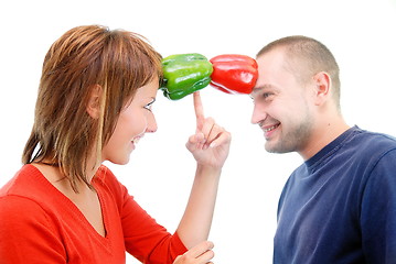 Image showing happy couple holding peppers with head