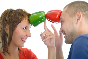 Image showing happy couple holding peppers with head