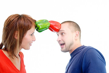 Image showing happy couple holding peppers with head