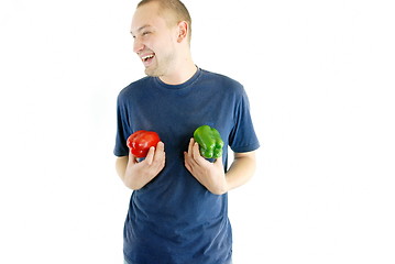 Image showing happy couple holding peppers with head