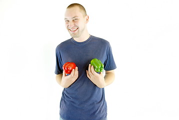 Image showing happy couple holding peppers with head