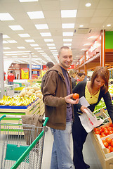 Image showing happy couple buying fruits in hypermarket