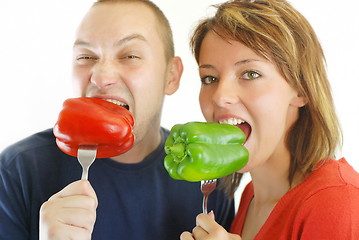 Image showing happy couple with eating  peppers 