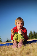 Image showing happy girl eating healthy food in nature