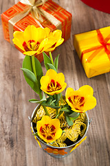 Image showing It is red yellow tulips and gift boxes, a close up