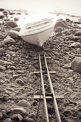 Image showing Fishing boat on stony to seacoast