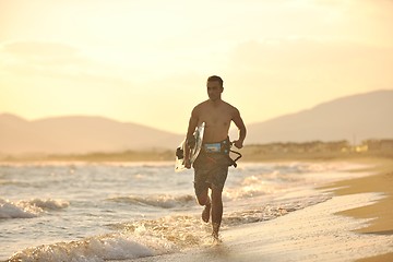 Image showing Portrait of a young  kitsurf  man at beach on sunset