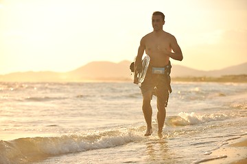 Image showing Portrait of a young  kitsurf  man at beach on sunset