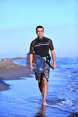 Image showing Portrait of a young  kitsurf  man at beach on sunset