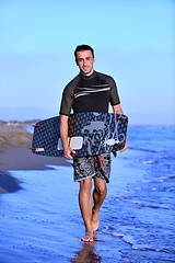 Image showing Portrait of a young  kitsurf  man at beach on sunset