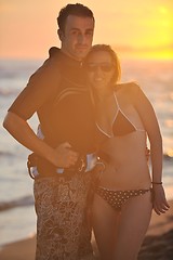 Image showing surf couple posing at beach on sunset